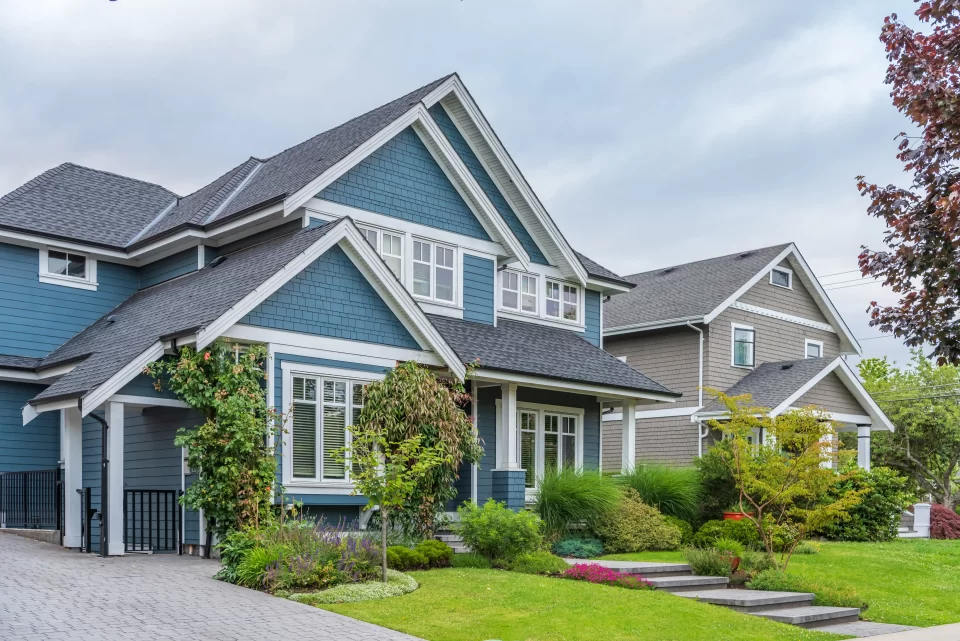 A row of elegant two-story suburban homes with a mix of gray and blue sidings and white trims installed by Shingle Masters.