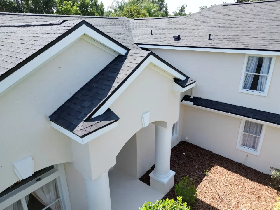 Aerial view of a home with a new black asphalt shingle roof installed by Shingle Masters Roofing & Construction
